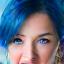 Profile picture of Sarah L., a young woman with vivid blue hair and a joyful expression.
